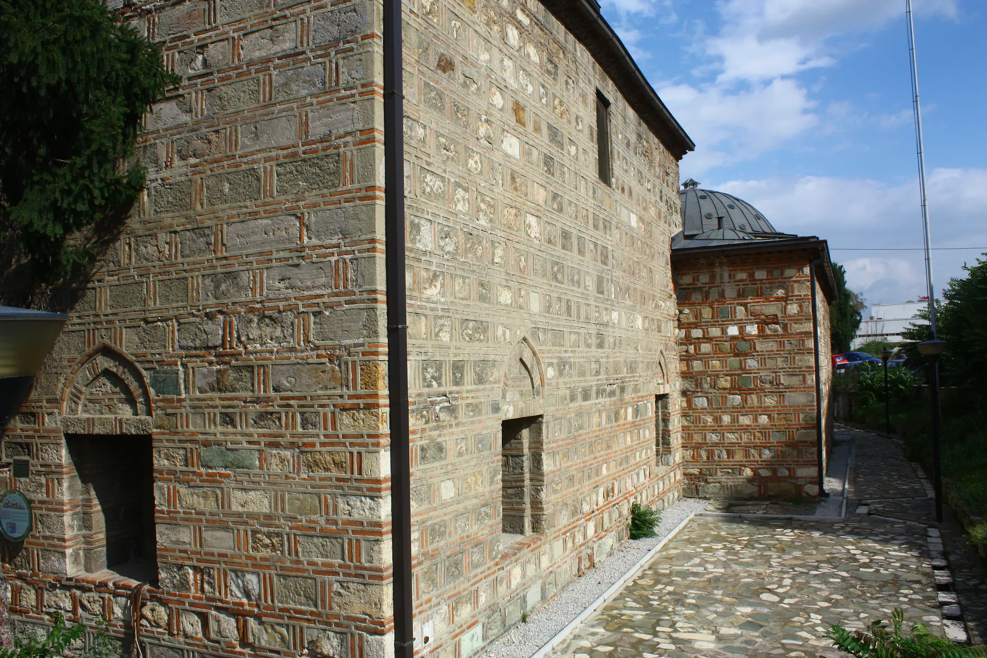 Stone-and-brick side wall and cobbled path at Daut Pasha Hamam in Skopje