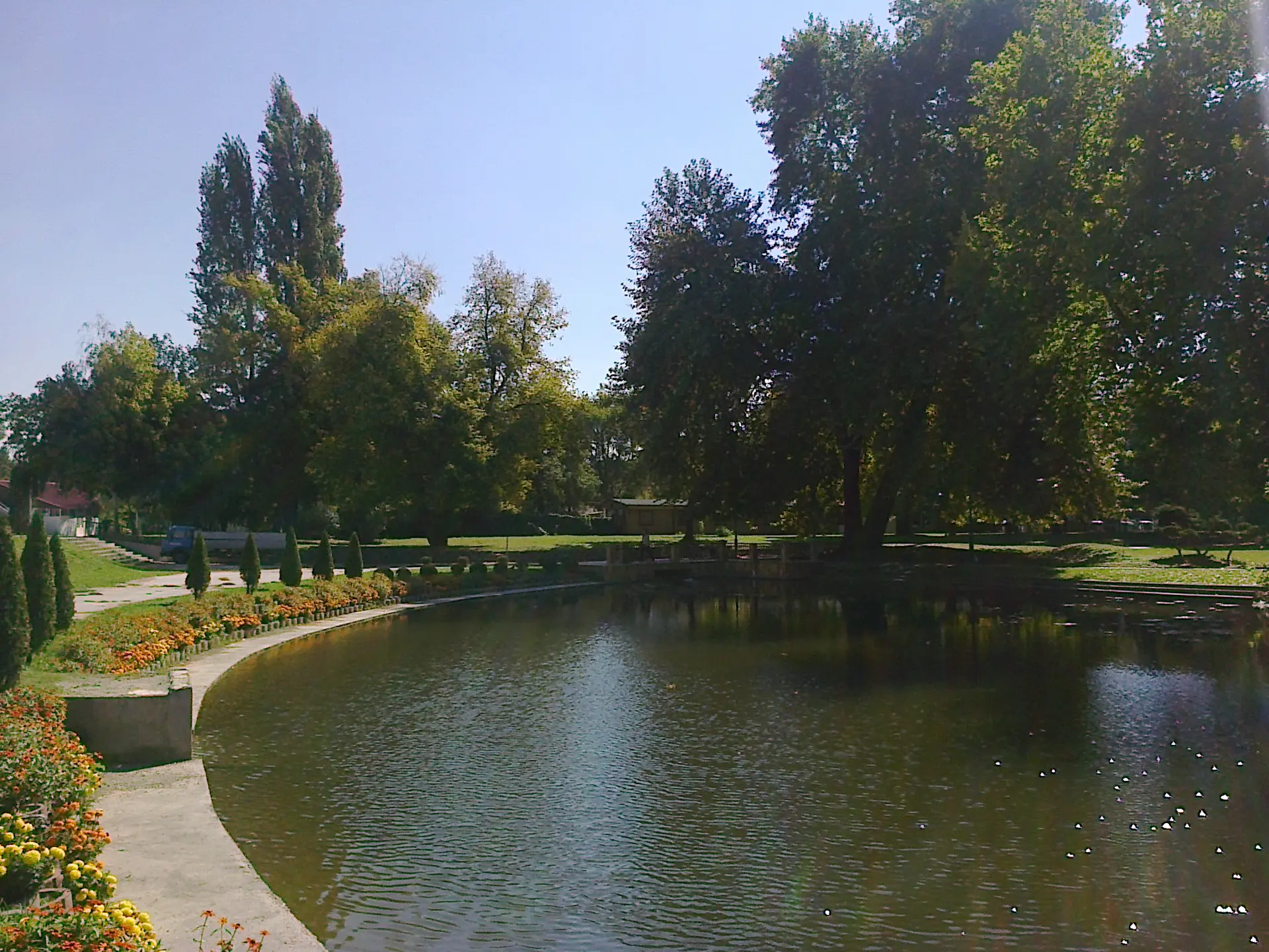 Lake edged by flowers and mature trees in Skopje City Park